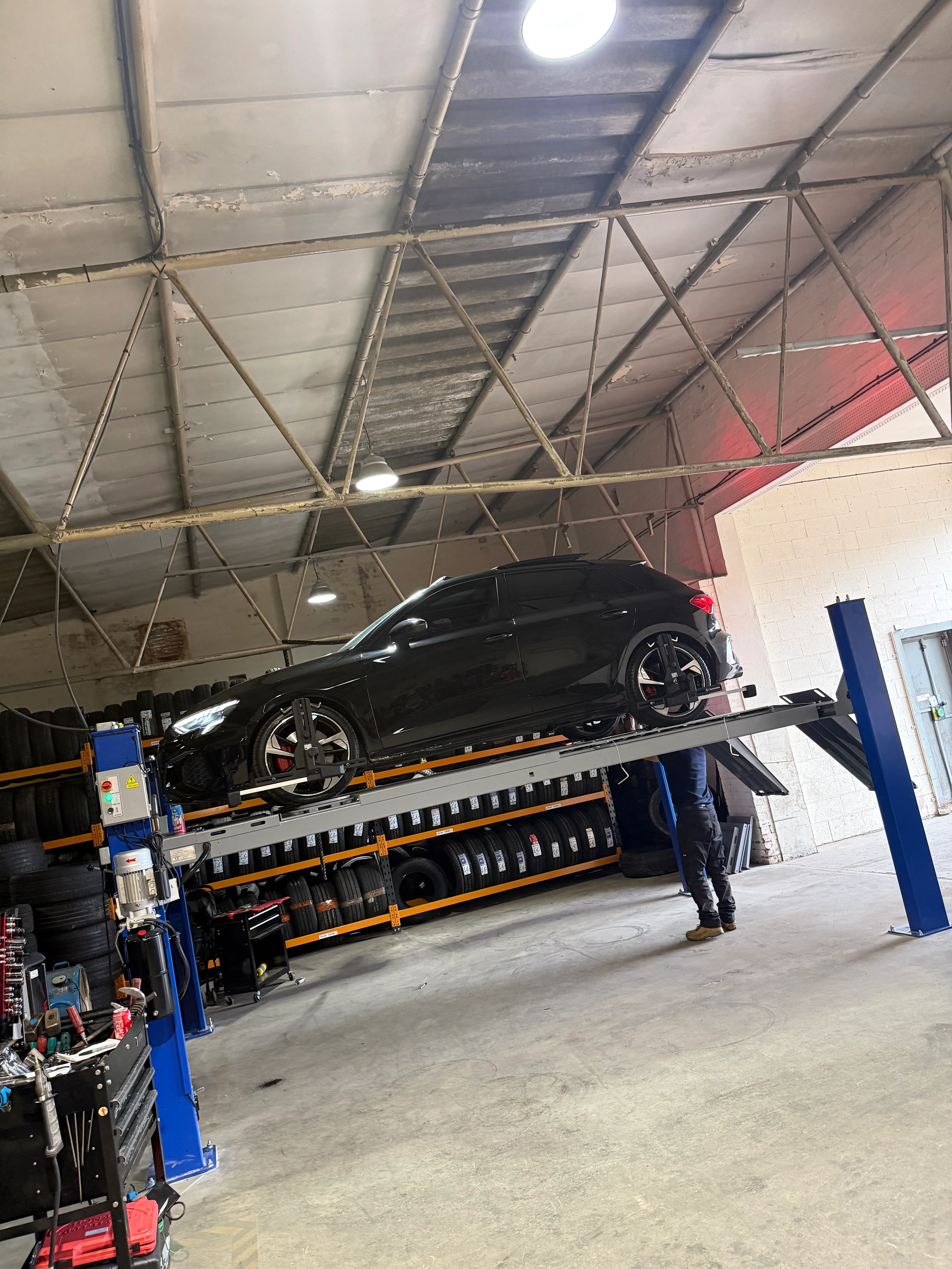 An audi on a ramp inside a garage.