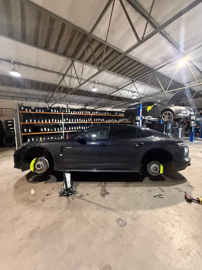 A Porsche on a ramp inside a garage.